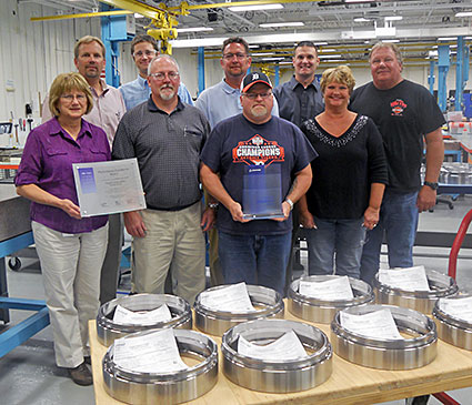 Members of the Plant One (Muskegon) team, shown with the Boeing award and samples of Kaydon bearings. (Front, L-R) Barb Werner, Tom Bisson, Delbert Lee, Debbie Hibbard. (Back, L-R) John Saber, Branden Workman, Todd Bramer, Joe Vossekuil, Chuck Hibbard.