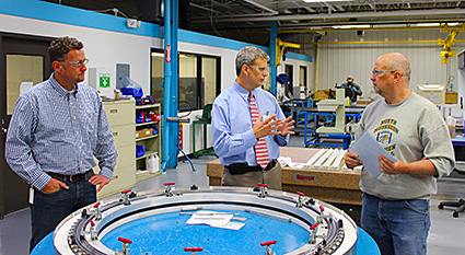 Todd Bramer, Rep. Huizenga, and Kaydon associate Gary Galdeen discuss Kaydon's assembly process.